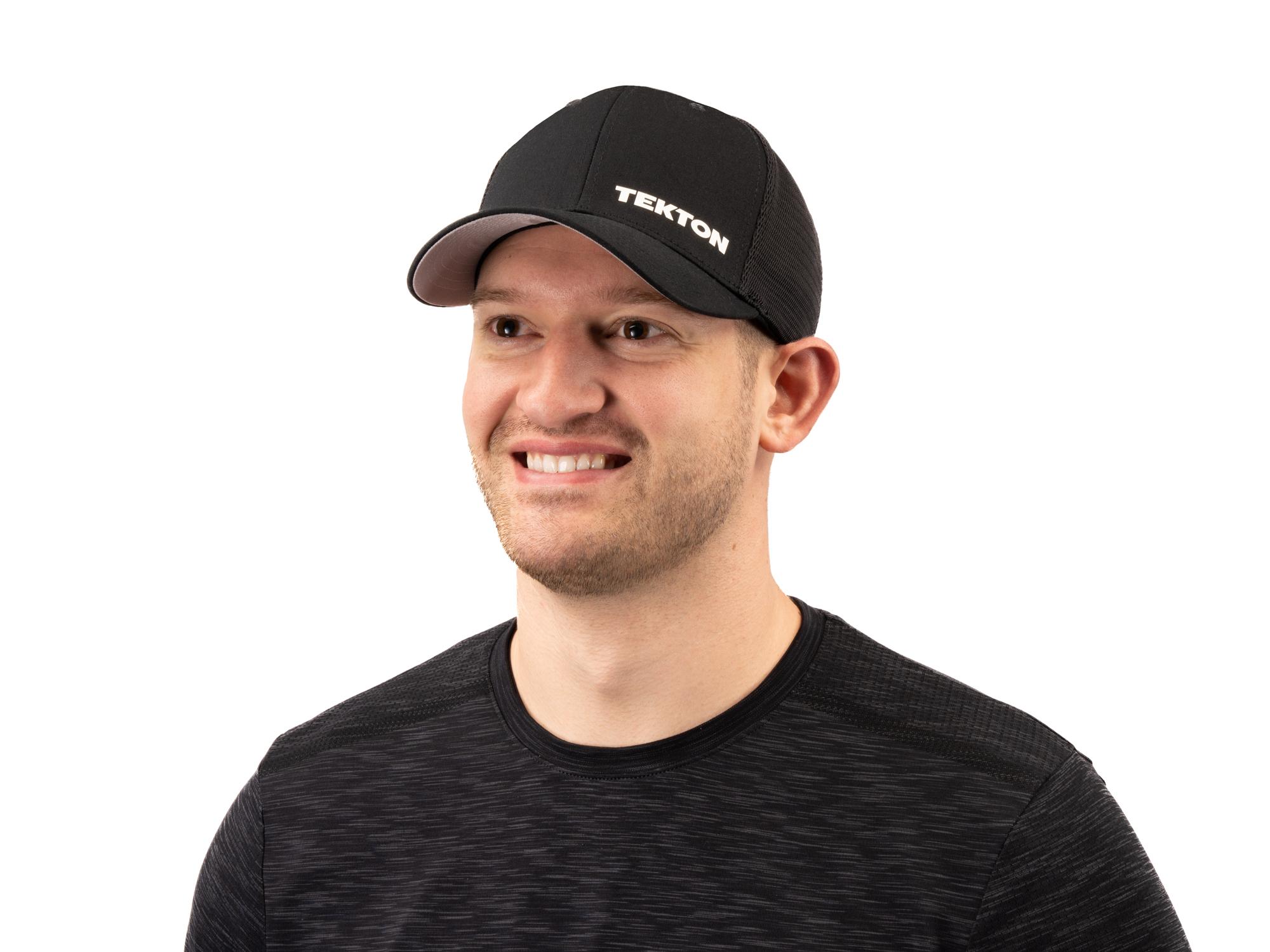 A person smiling and wearing a black Tekton hat. Item #APG31005.