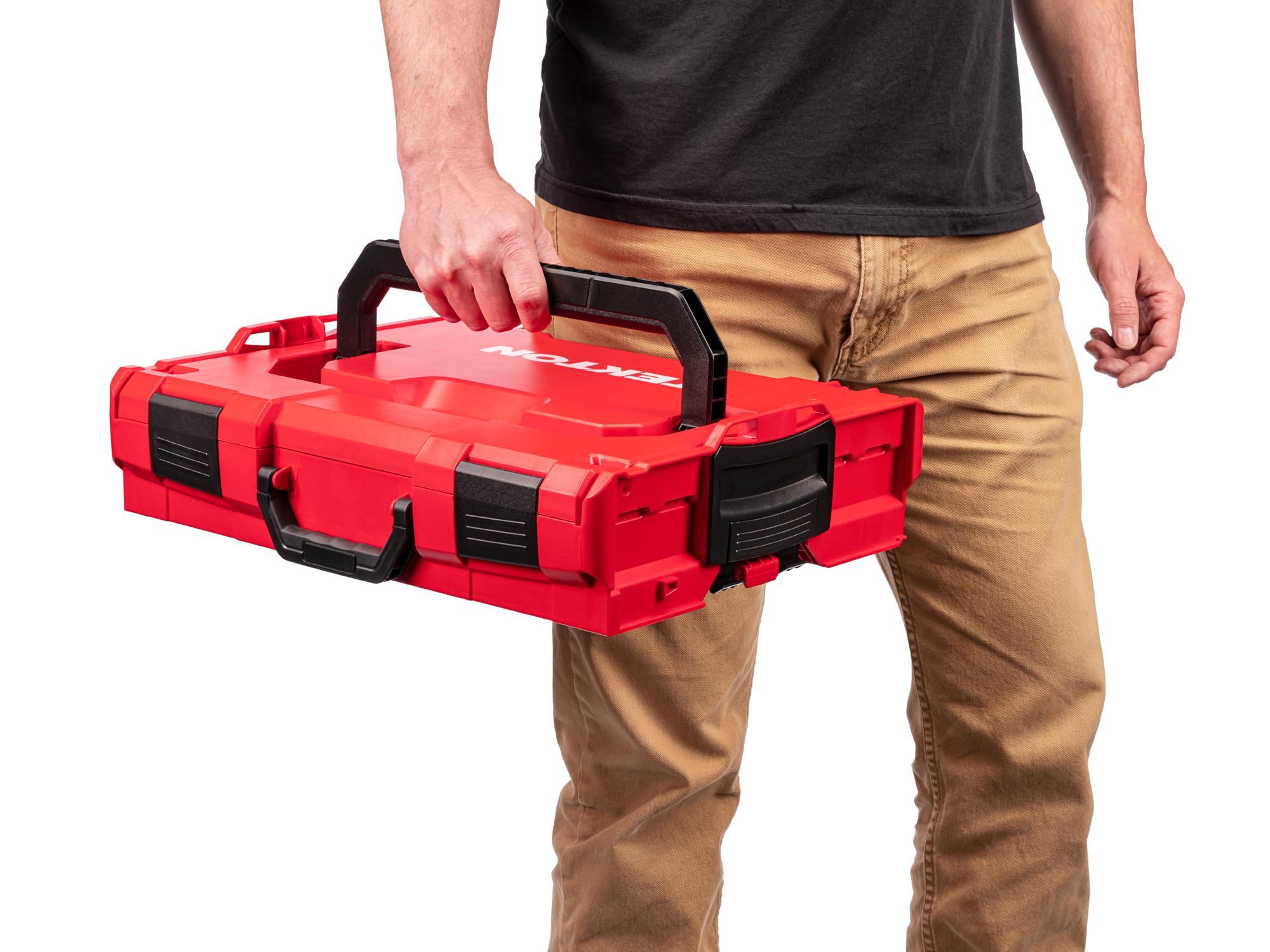 A person holding Tekton's stacking tool box by the top handle. Item #OLB11021.