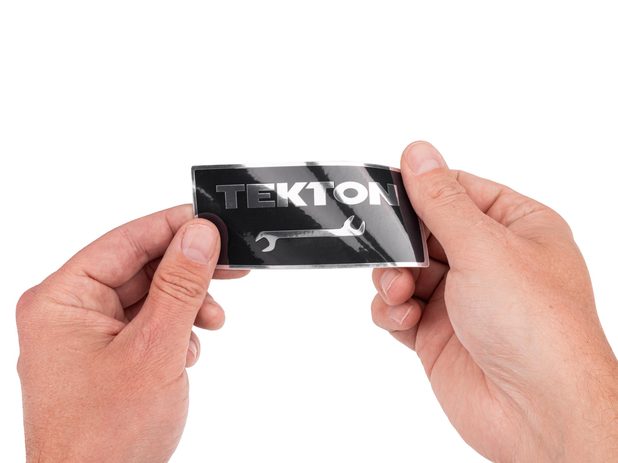 Person holding black Tekton sticker. Item #APG51012