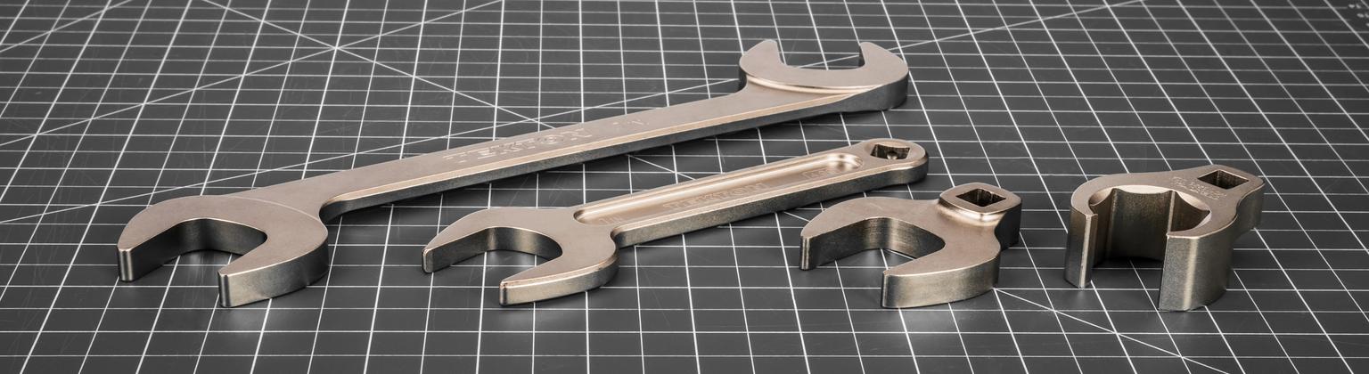 Tekton angle, service, crowfoot, and flare nut crowfoot wrenches on a gray mat.