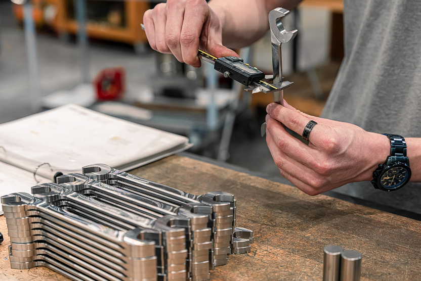 A person measuring a tekton angle head wrench