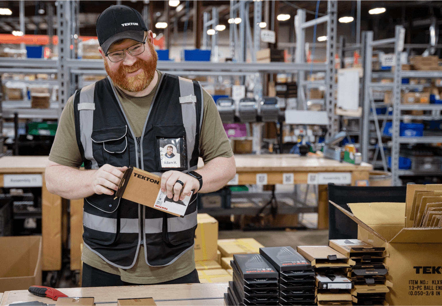 Fulfillment specialist packing tools in shipping boxes in a warehouse. 