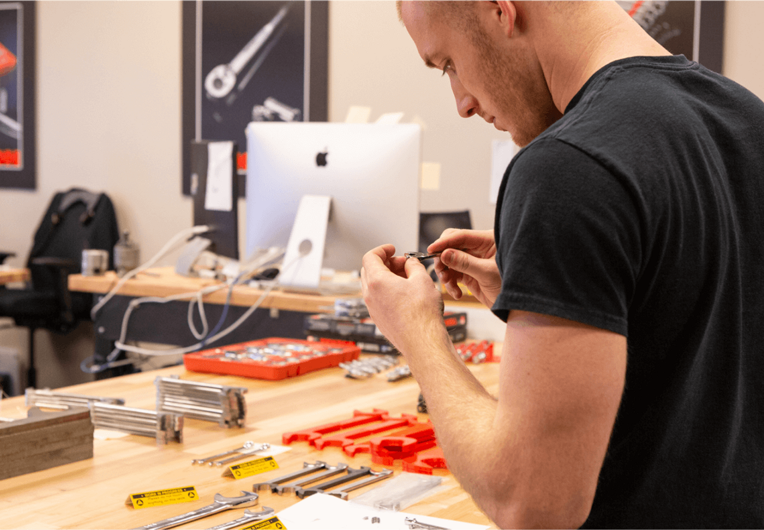 Product designer inspecting hand tools by a work bench.