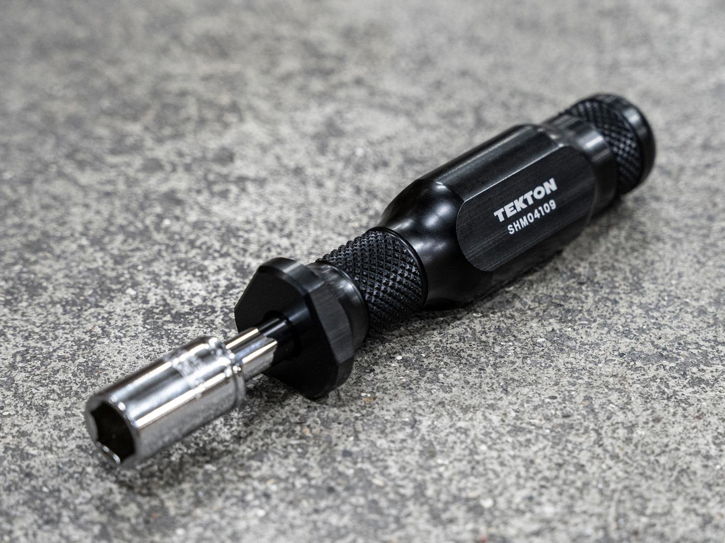 A spinner handle and socket on a concrete surface.