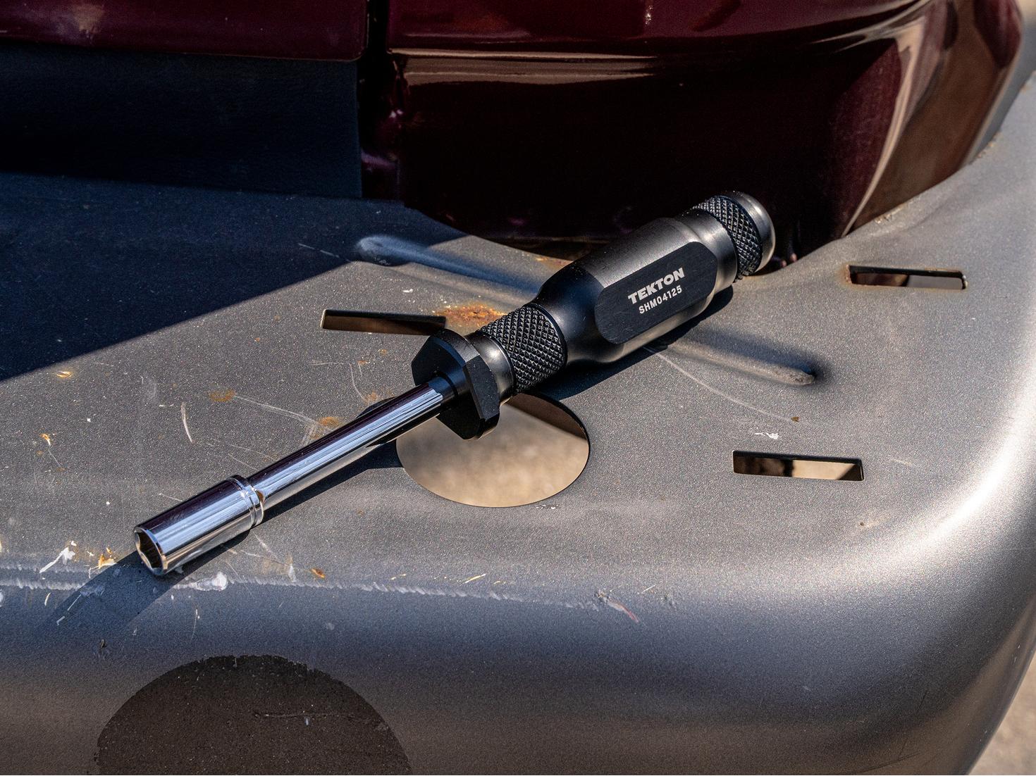 A spinner handle and socket on the bumper of a vehicle.
