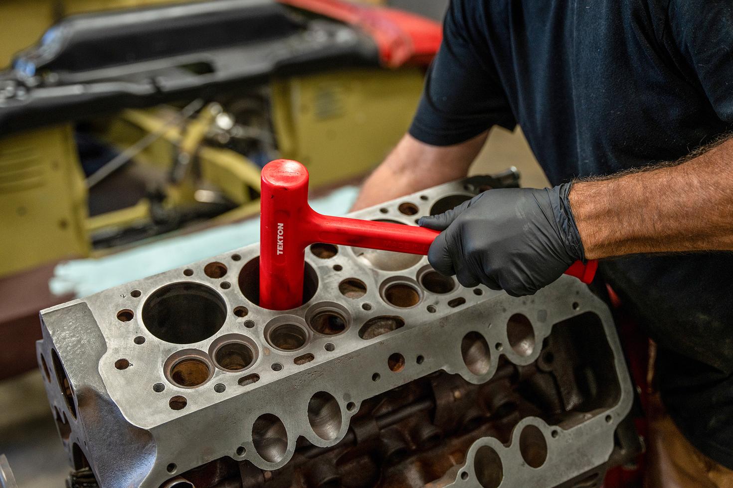 A Tekton piston hammer being used to drive a piston into the bore.