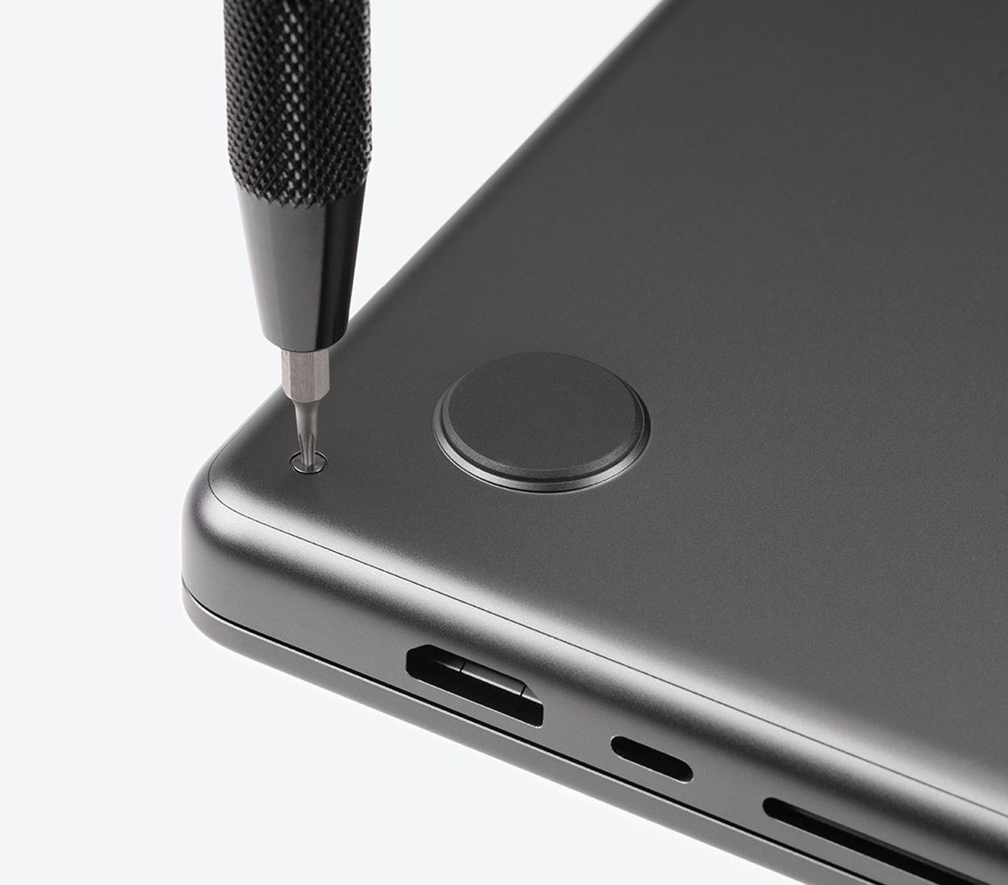 4 mm bit and bit driver removing a screw on the bottom of a laptop computer.