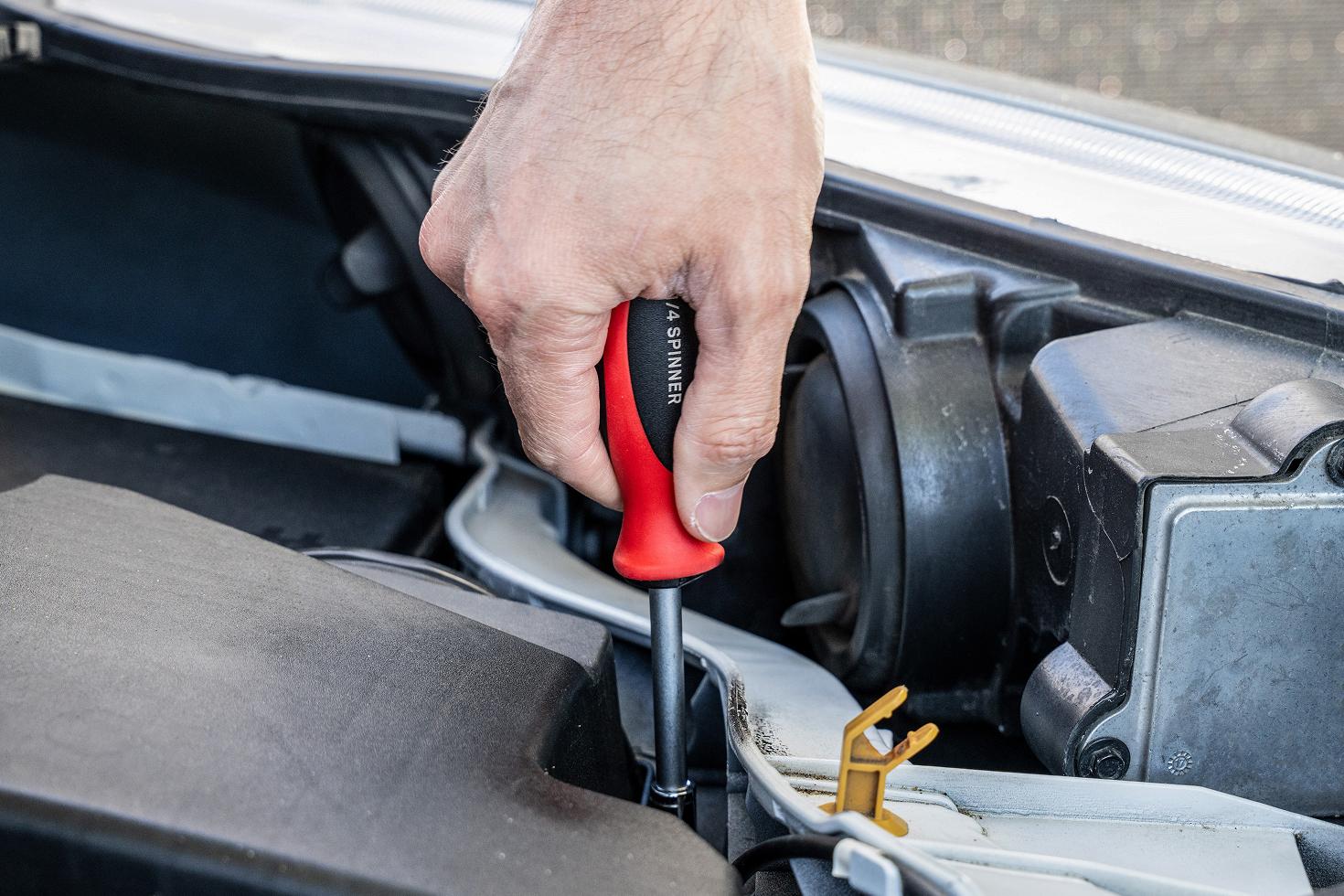 A spinner handle being used in a vehicle engine bay
