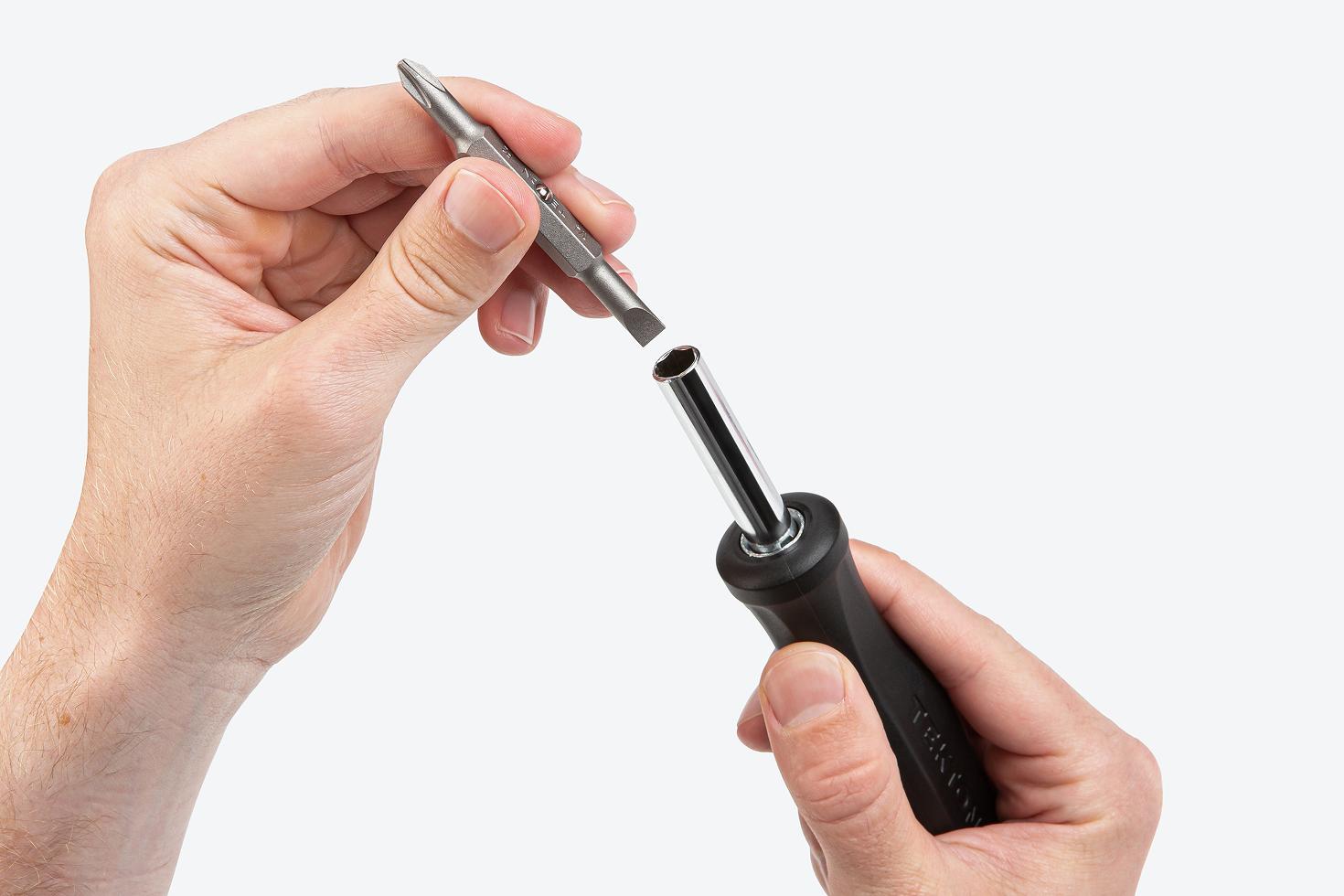 A Phillips/slotted screwdriver bit being removed from a 6-in-1 driver