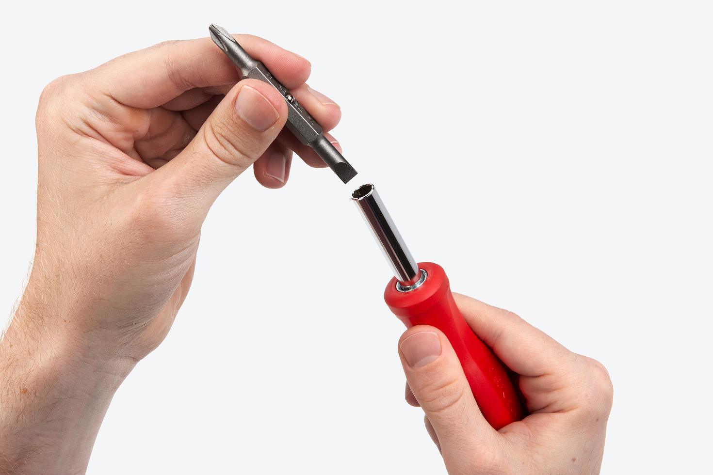 A Phillips/slotted screwdriver bit being removed from a 6-in-1 driver