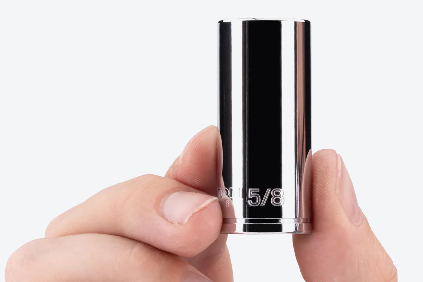 A person holding a 5/8 inch chrome socket, showing the markings