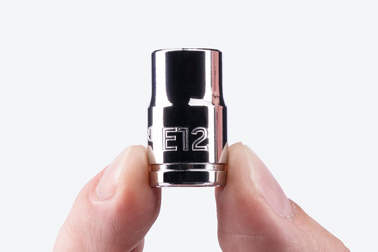 A Tekton 3/8 Inch Drive x E12 External Star Socket being held, showing the large stamped "E12" markings.