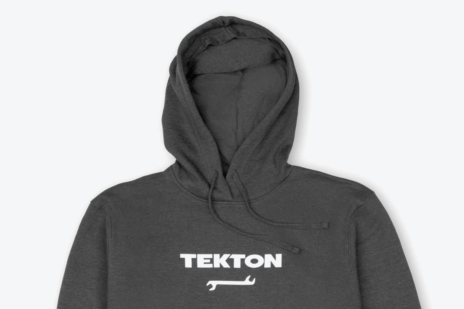 A dark heather gray heavyweight Tekton hoodie laying out on a light gray surface.