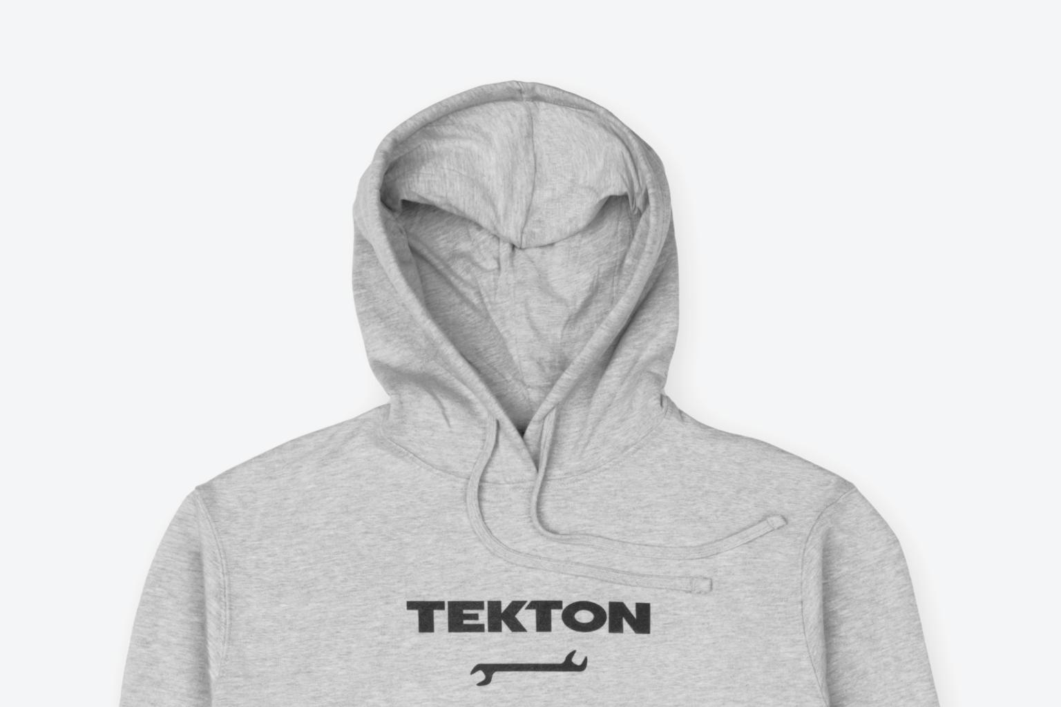 A light heather gray heavyweight Tekton hoodie laying out on a light gray surface.