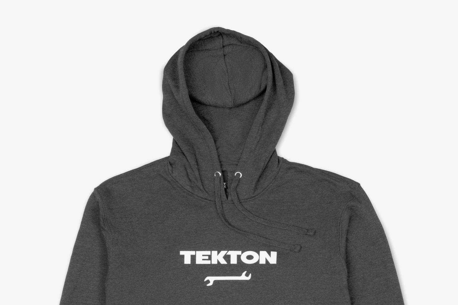 A dark heather gray midweight Tekton hoodie laying out on a light gray surface.