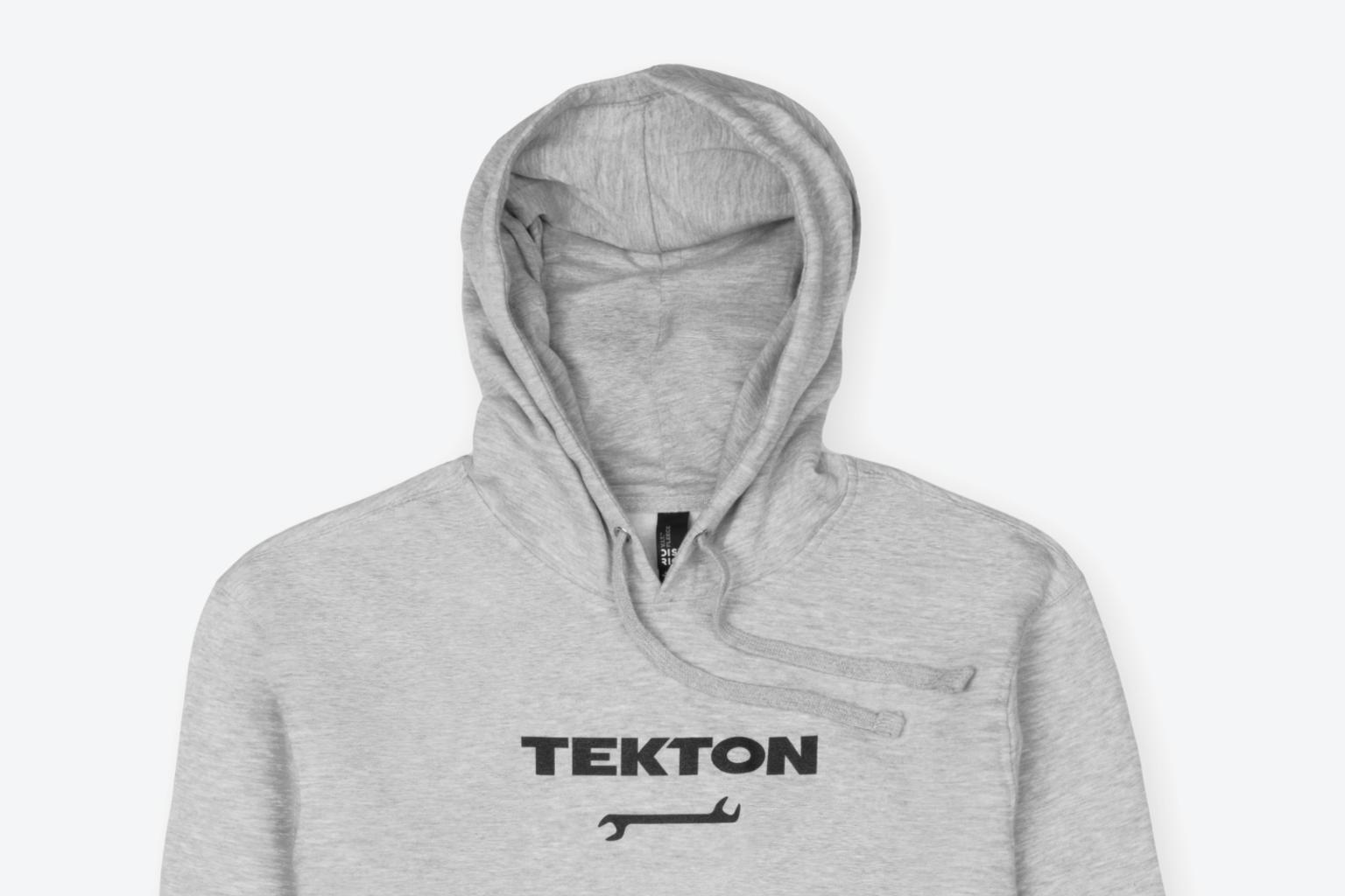 A light heather gray midweight Tekton hoodie laying out on a light gray surface.