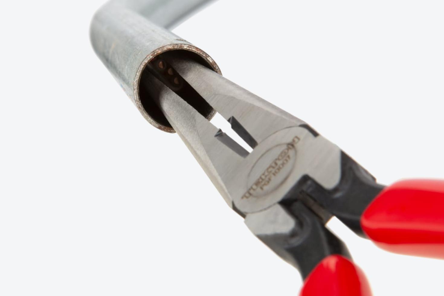 Pliers reaching into a pipe