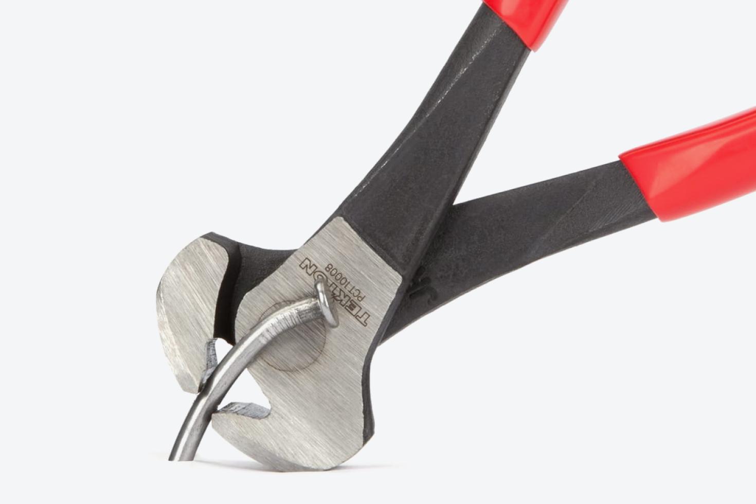 The pliers prying a nail out of a surface