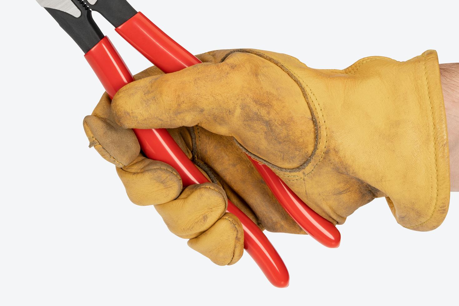 A hand in a yellow glove holding the pliers