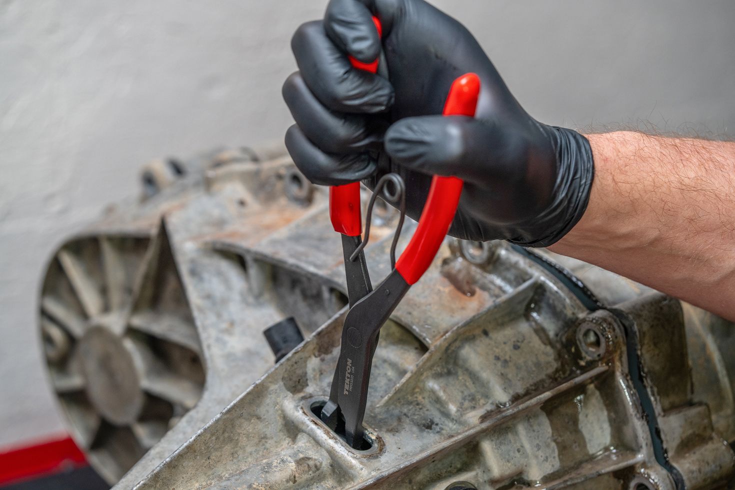 A pair of 90-degree Tekton lock ring pliers (#PRR53205) being used to open a retaining ring