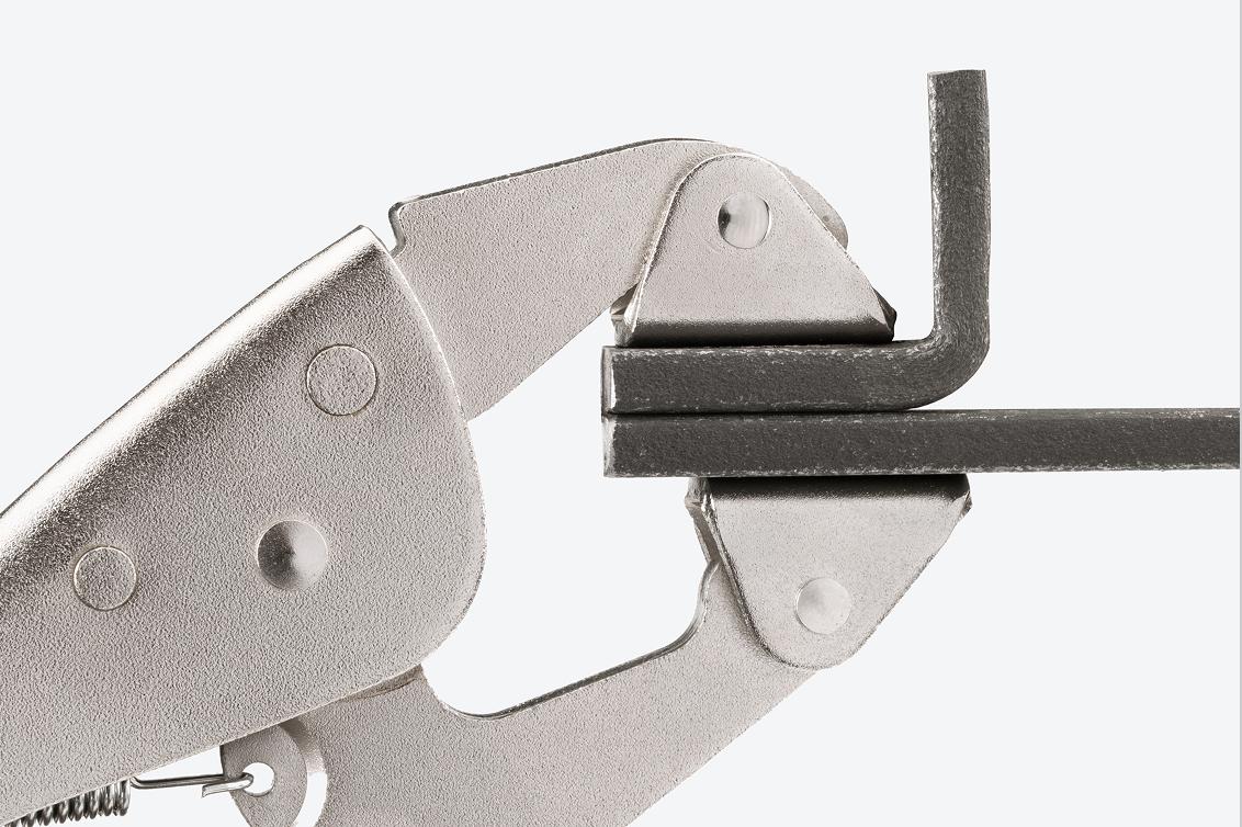 A clamp clamping down on two pieces of steel.