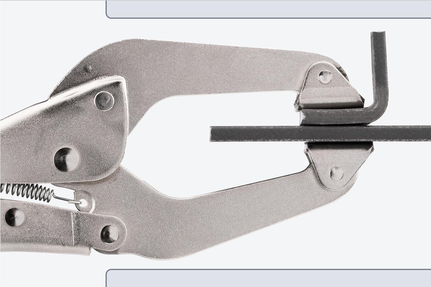 A clamp clamping down on two pieces of steel.