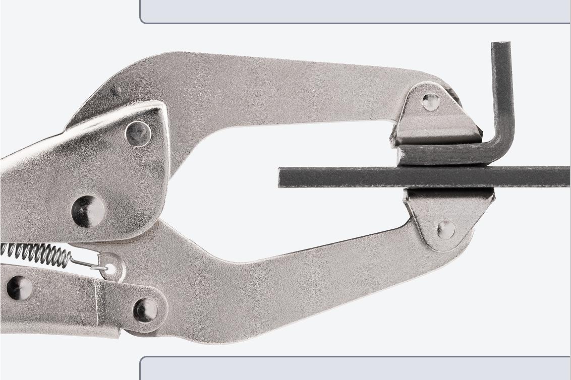 A clamp clamping down on two pieces of steel.