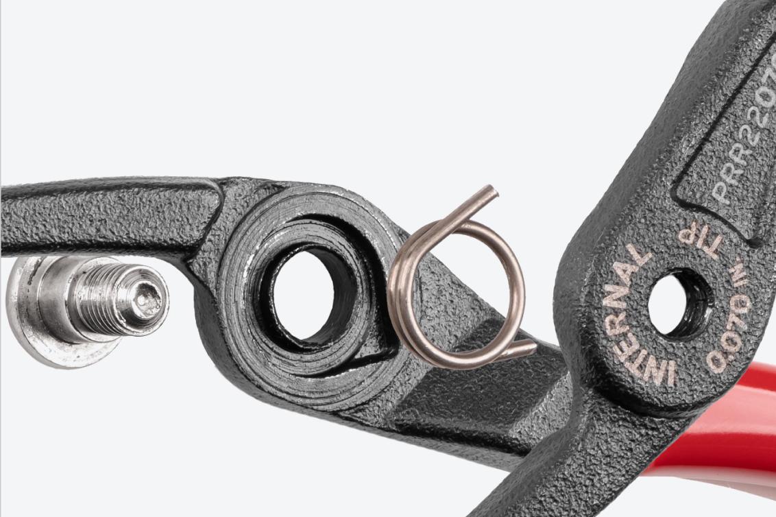 Close-up exploded view of Tekton retaining ring pliers, showing the spring and bolt.