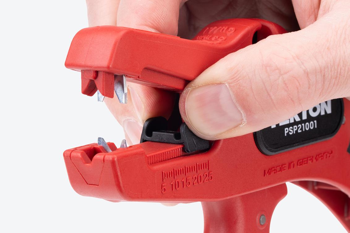 A hand adjusting the length stop of the wire stripper