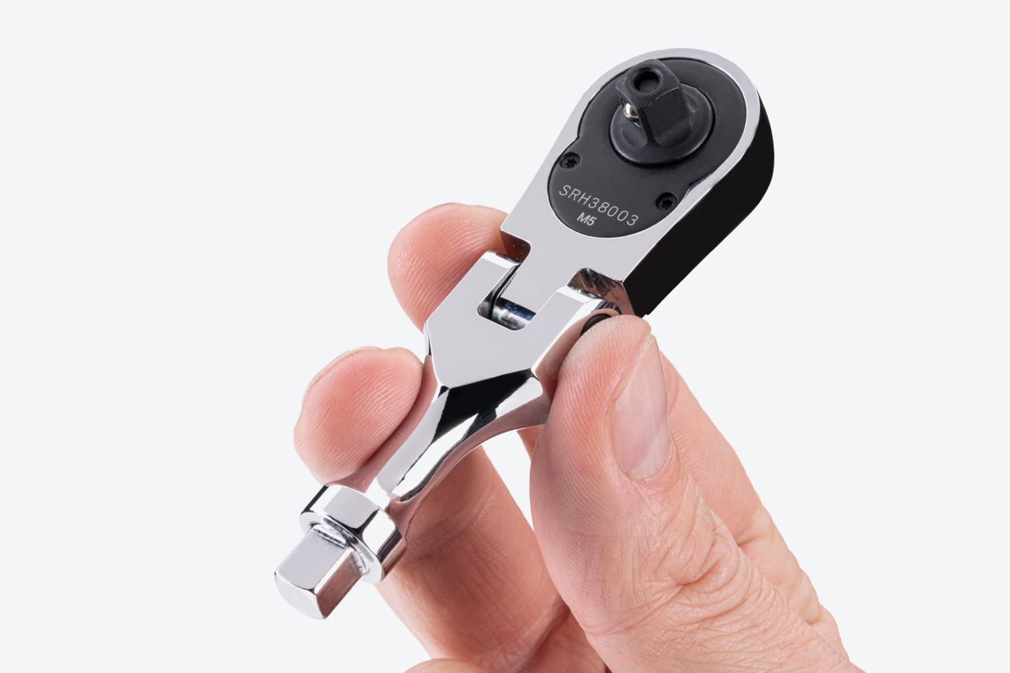 A 1/4 inch drive stubby ratchet with handle tang being held