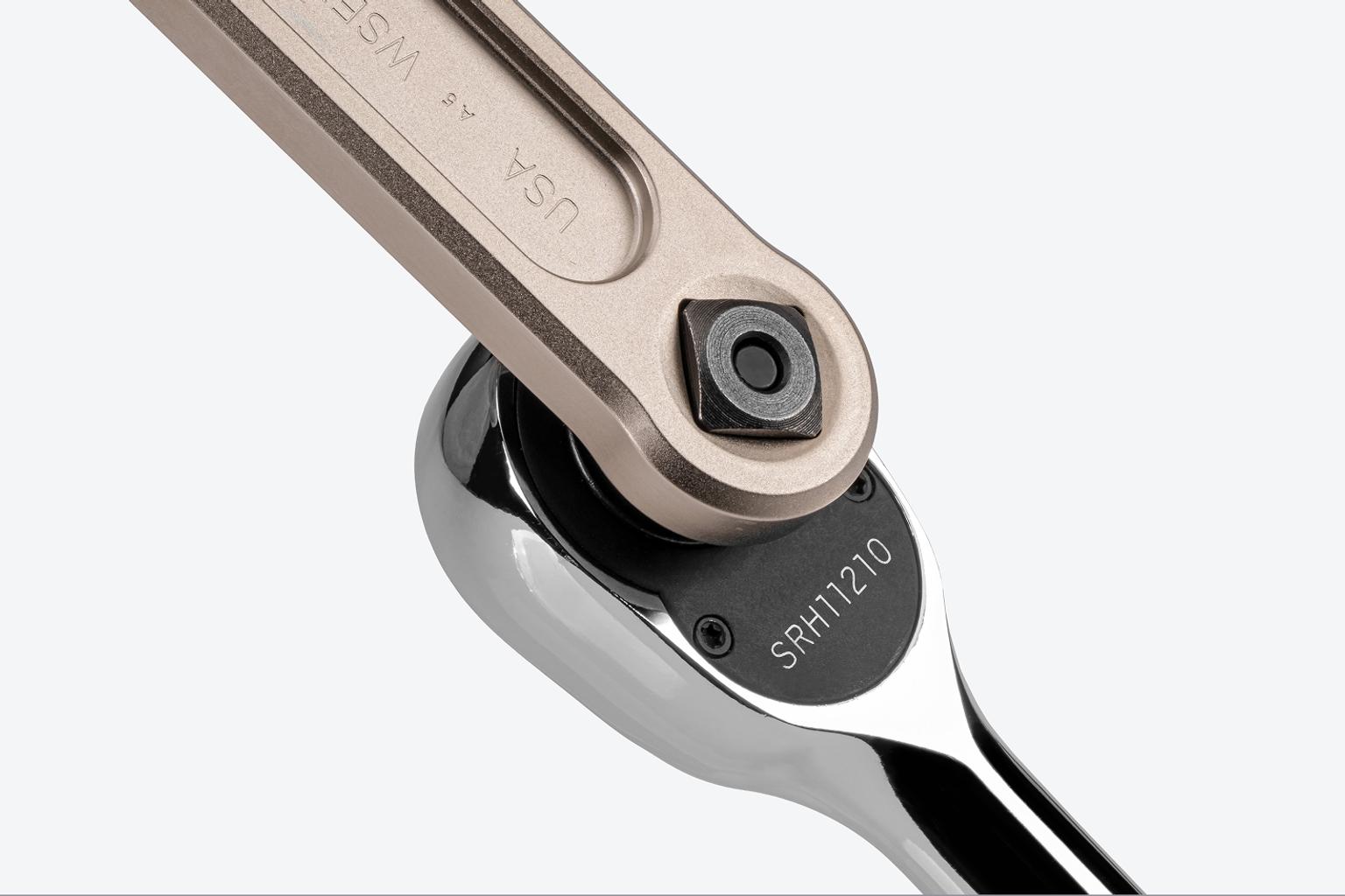 A ratchet connected to the drive square in the handle of a Tekton service wrench.