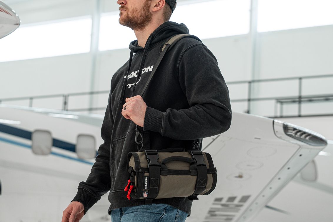 A man carrying a Tekton MTR tool roll using the strap.