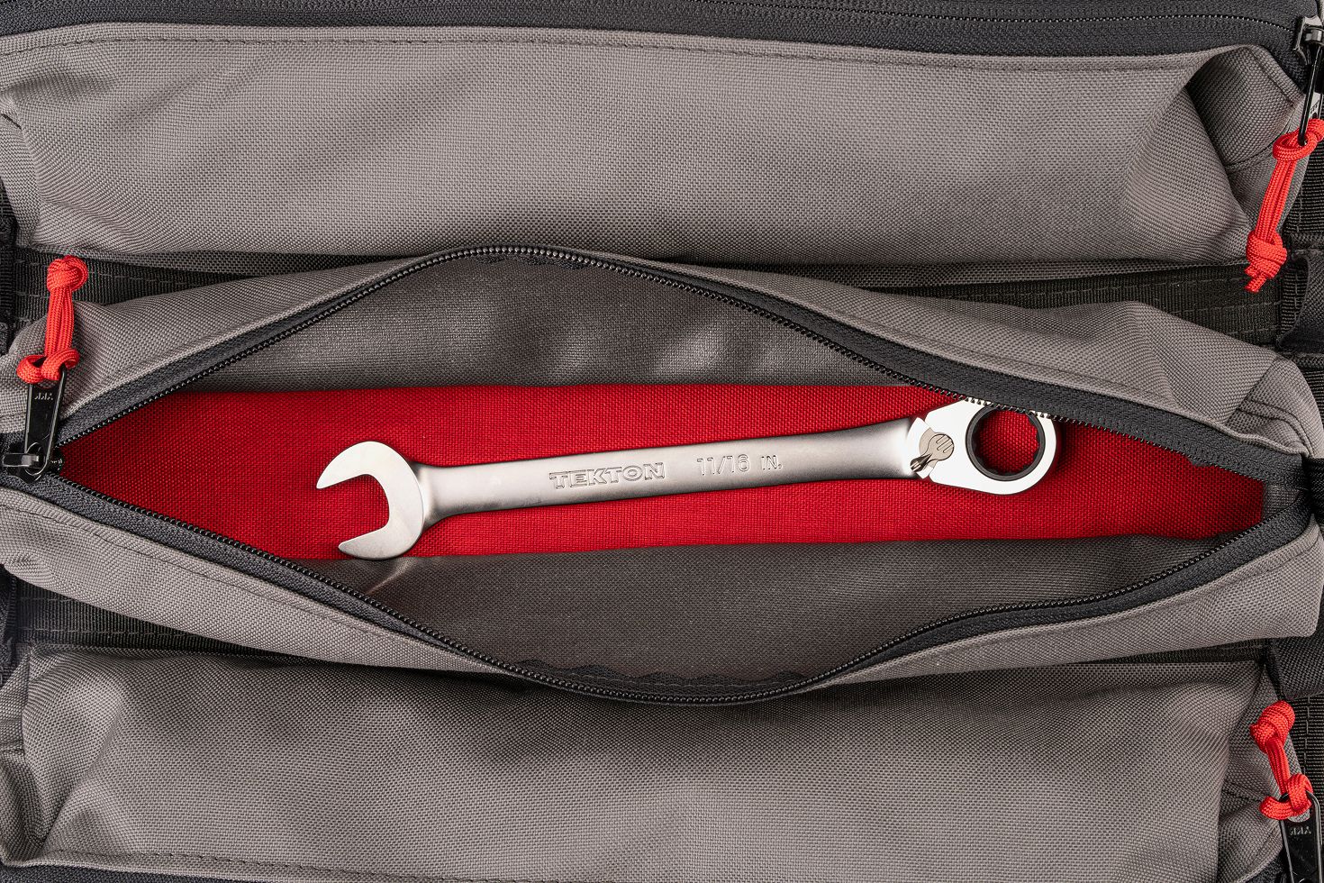 A ratcheting combination wrench in a pouch with the red layer showing