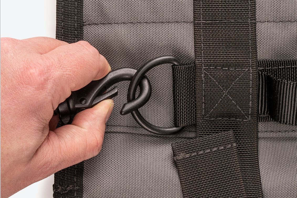 A hand opening the metal swivel snap hook