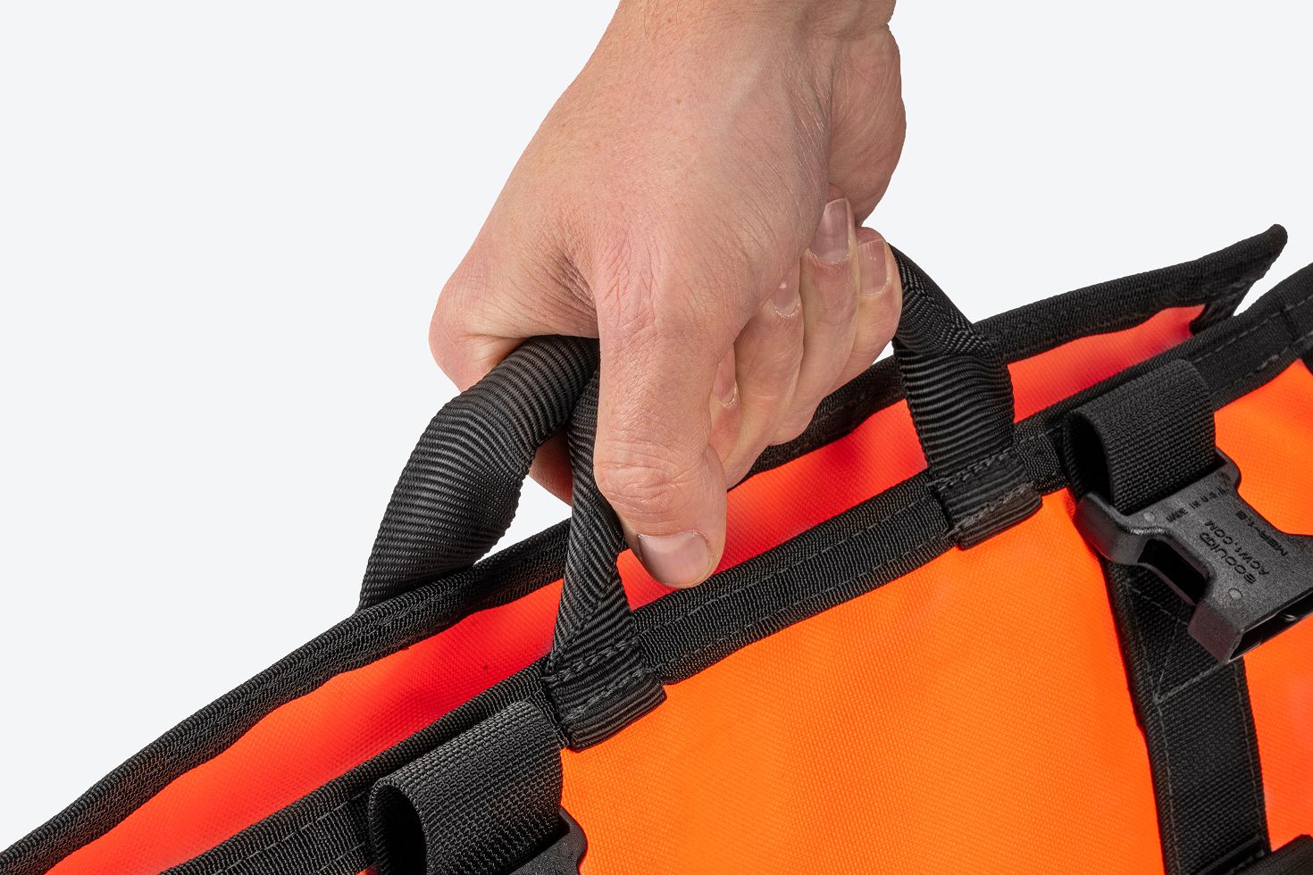 A hand holding an orange MTR with the handles.