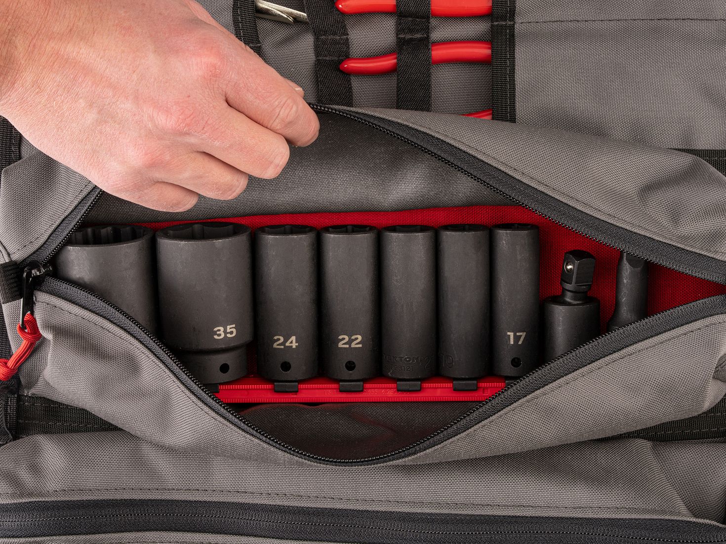 A deep impact socket set on a red rail in the pouch of a gray MTR