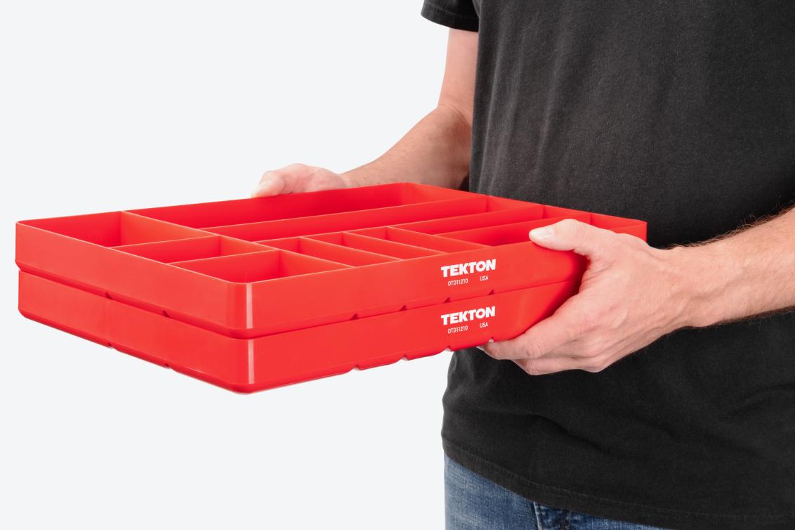 A person holding two red 10-compartment organizer trays