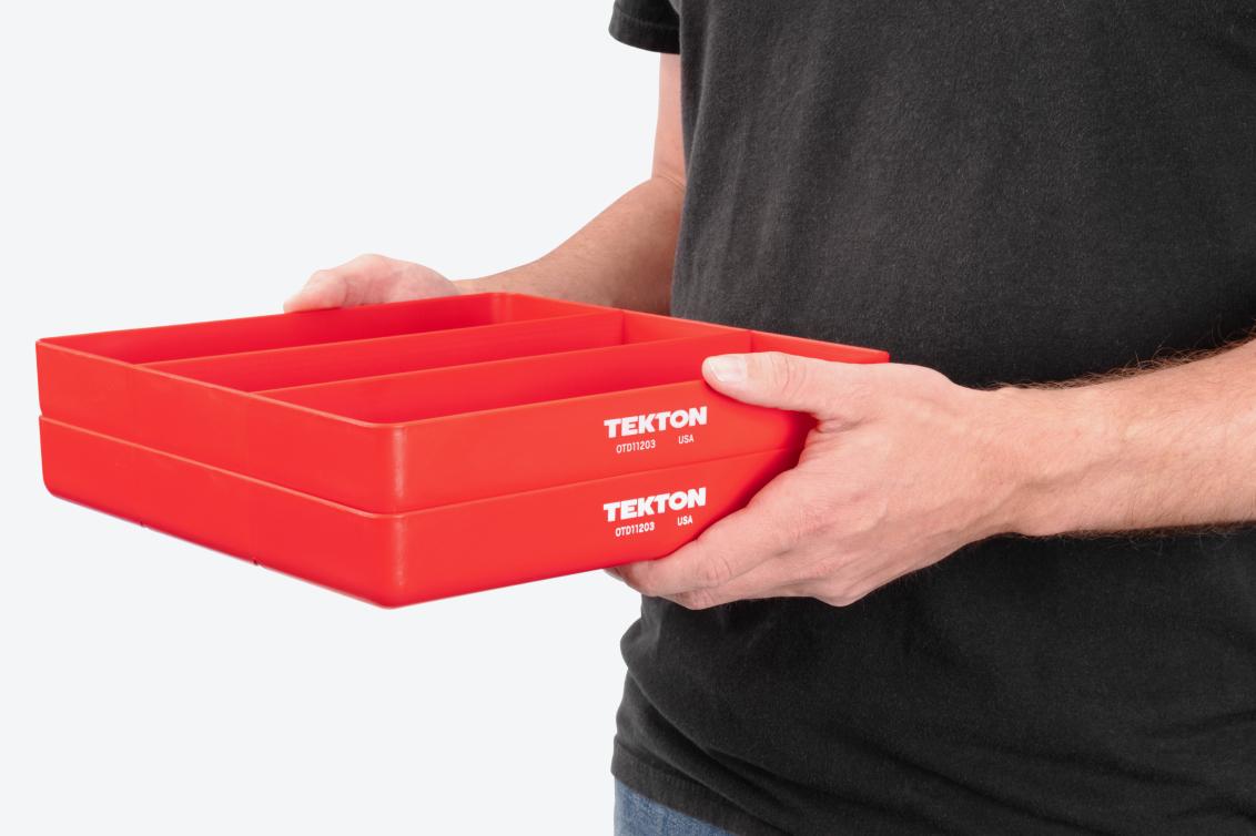 A person holding two red 3-compartment organizer trays