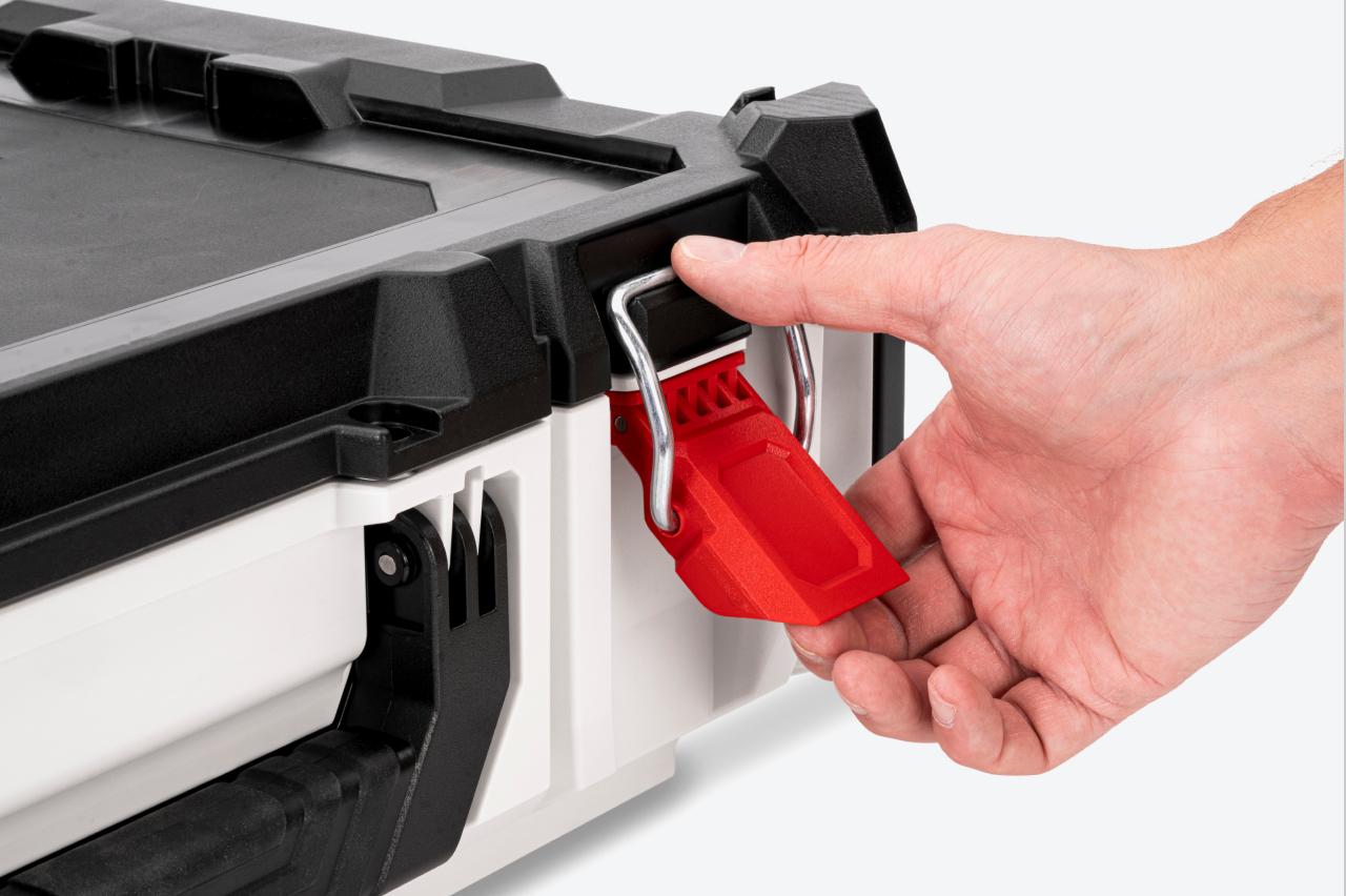A red latch on a tool box being opened