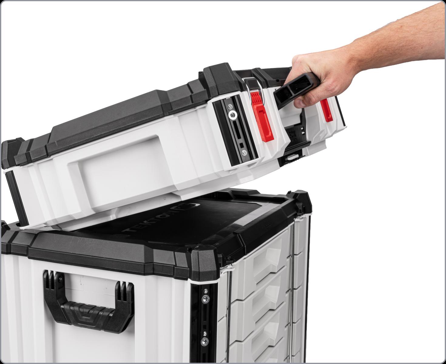 A hand lifting a tool box away from a stack of boxes