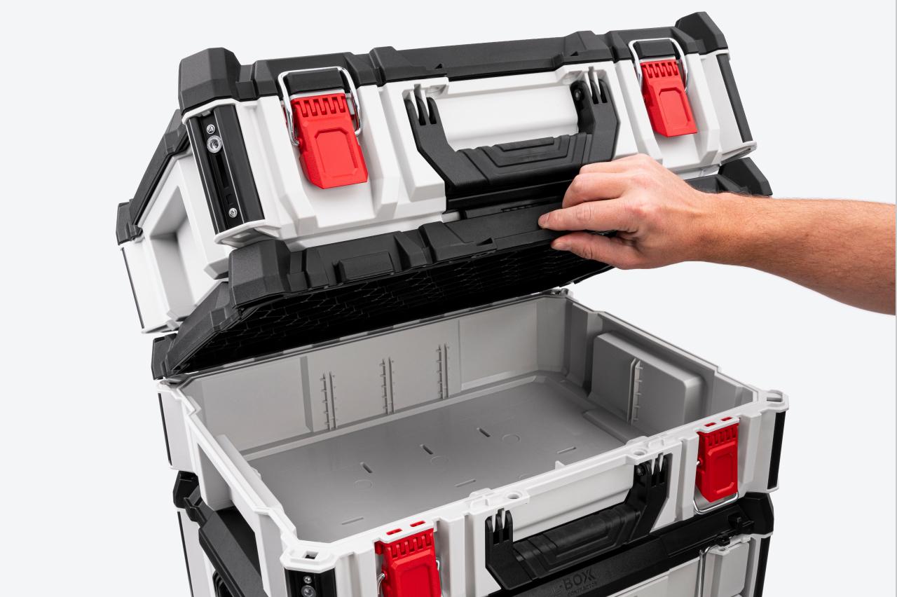 The lid of a tool box being opened. Another tool box is stacked onto the lid.