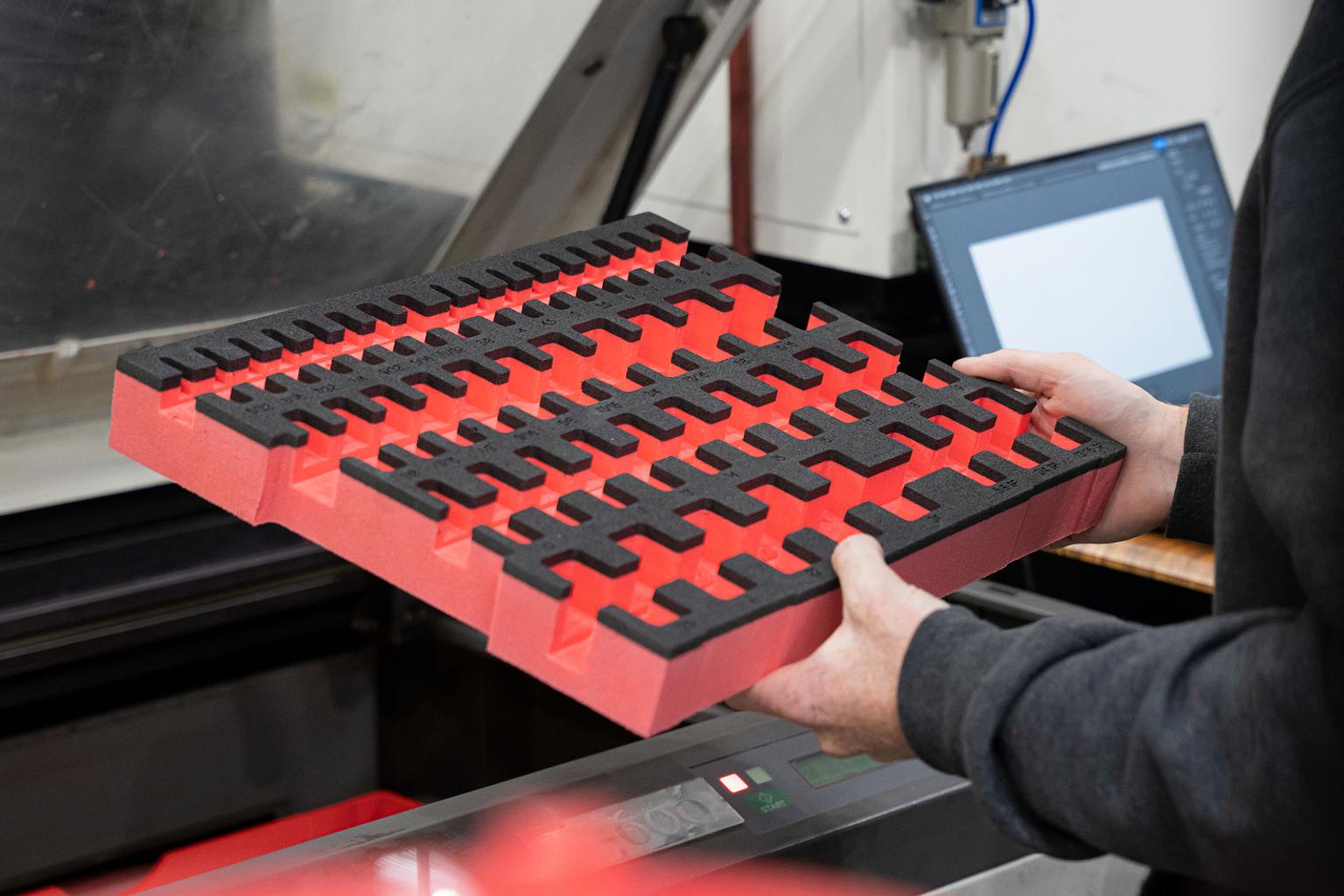A manufacturer holding a cut sheet of foam.