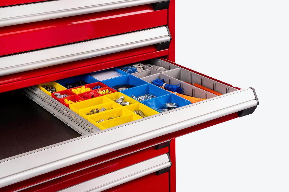 A red Tekton tool cabinet with an open drawer filled with yellow, red, blue, and gray shallow organizer bins.