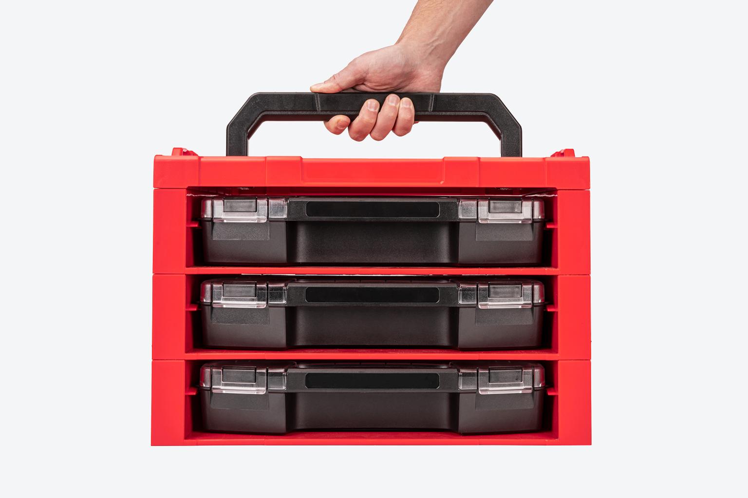 A hand carrying a stack of drawers with a top.