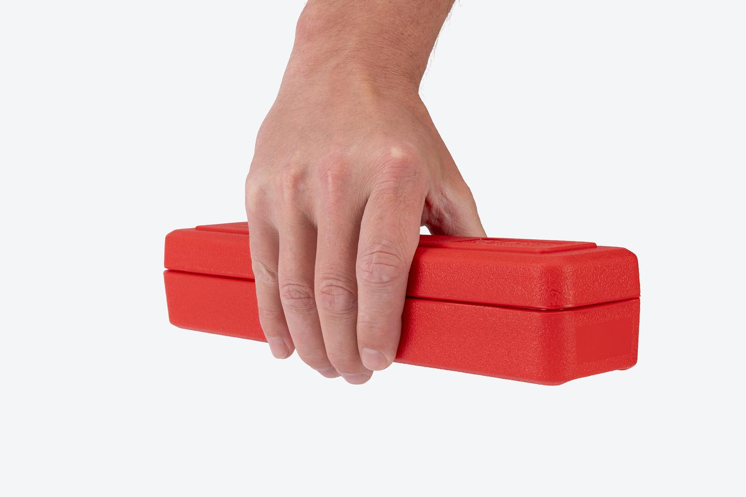 Hand holding a red torque wrench case.