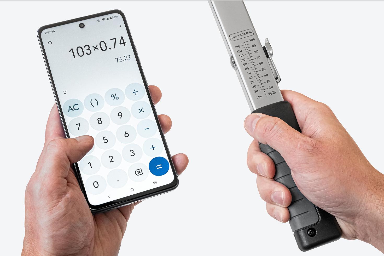 One hand holding a phone with a calculator app, the other holding a torque wrench with the scale visible