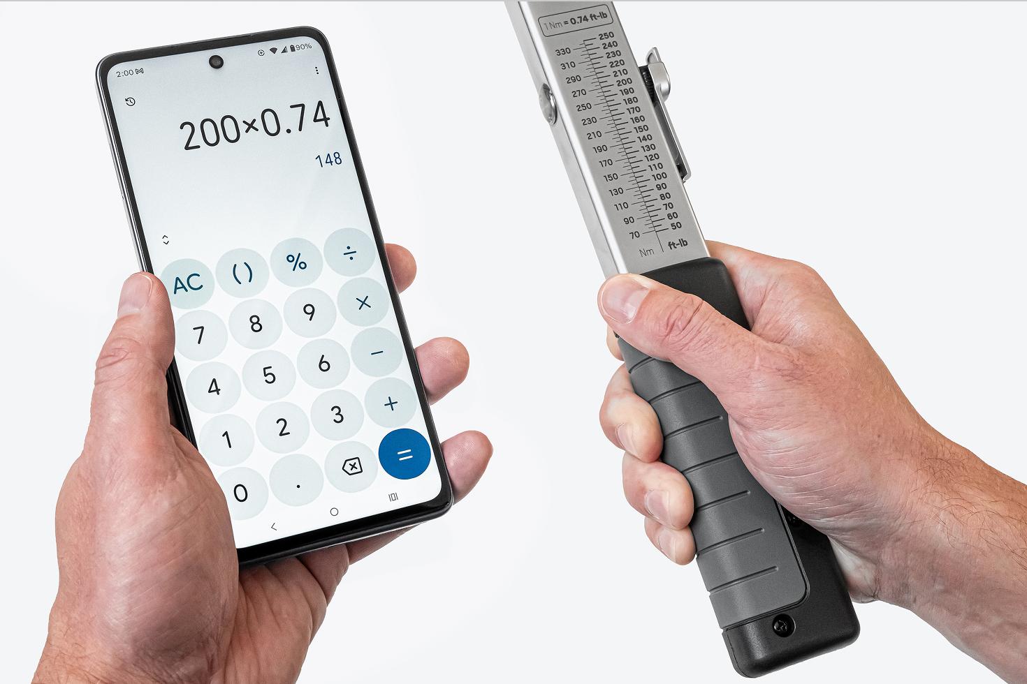 One hand holding a phone with a calculator app, the other holding a torque wrench with the scale visible