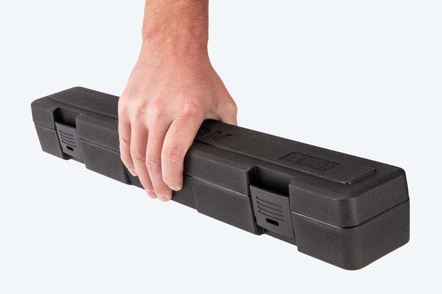 Hand holding a black torque wrench case.