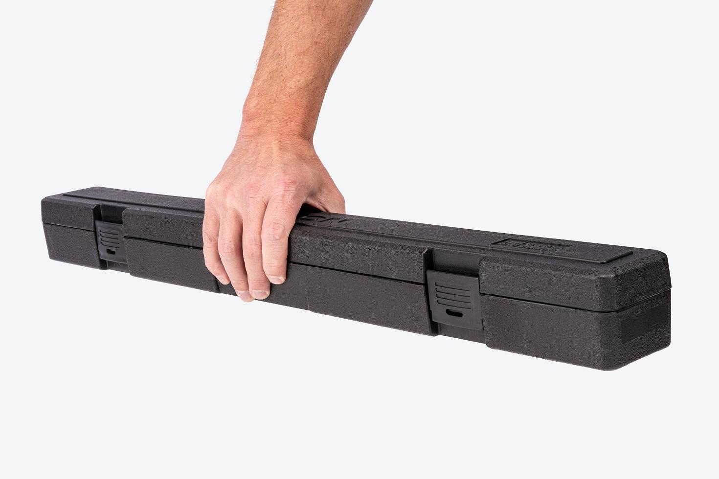 Hand holding a black torque wrench case.