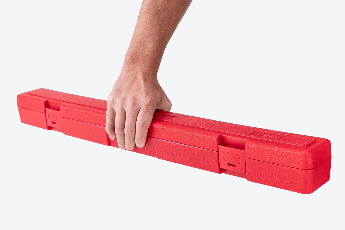Hand holding a red torque wrench case.